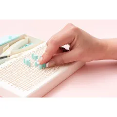 Happy Jig Zange schneidet Draht ab, hand hält Jig, rosa Hintergrund, Verpackung im Hintergrund