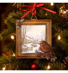 Goldfarbener Rahmen-Anhänger mit Winterdorf-Motiv und aufgesetzter Rotkehlchen-Figur, mit roter Schleife an einem Weihnachtsbaum hängend