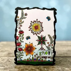 Schwarz gerahmte Karte mit Mandala-Blüte, Stern, roten Blüten, Ranken und Etikett grow