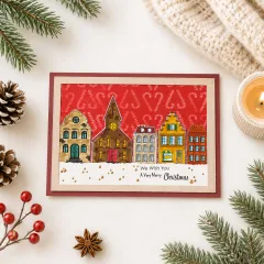 Weihnachtskarte mit rot geprägtem Zuckerstangen-Hintergrund und Häuserzeile im Schnee
