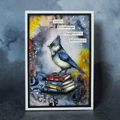 Handgemachte Karte mit blauem Vogel auf Buchstapel und Inspirationssprüchen