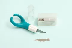 Comfort Craft Messer türkis mit weißem Griff und transparenter Klingenschutzbox mit Ersatzklingen