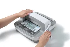 Anwenderin kurbelt die Big Shot Plus zum Stanzen und Prägen des eingelegten Sandwiches