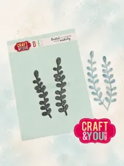 Metallstanzform neben zwei coloriert ausgestanzten Pflanzenzweigen auf mintgrünem Untergrund