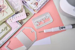 Gestanzte Mini Tags auf Journalseiten, daneben Tag-Stanze, Wortrahmen und Sizzix-Pick-Werkzeug