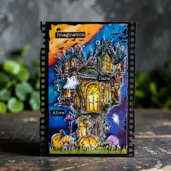 Schwarze Bastelkarte mit mehrfarbig bemaltem Spukhaus, Geistern, Kürbissen und Text 'Imagination', 'Dare', 'Alive' auf Film-Sprocket-Rahmen