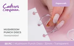 Hand setzt eine transparente Mushroom-Bindescheibe in ein gelochtes weißes Blatt vor rosa Hintergrund ein.