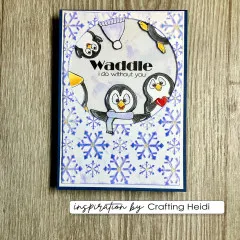 Karte mit blau colorierten geprägten Schneeflocken und Pinguin-Motiven im Kreis