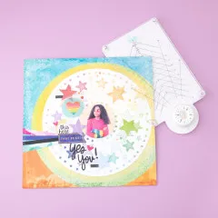 Rotating Precision Press liegt auf buntem Scrapbooking-Layout mit Sternen und Regenbogenelementen, Magnet-Drehrad sichtbar