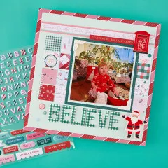 Scrapbook-Layout mit Foto, Alphabet-Stickern des Schriftzugs „Believe“ und Weihnachtsmann-Sticker
