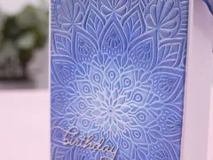 Blau kolorierte Mandala-Prägung mit gestempeltem Birthday-Schriftzug in Nahaufnahme