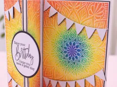 Regenbogenfarbig kolorierte Mandala-Prägung mit Wimpelketten und Geburtstagsgruß auf Faltkarte