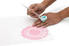 Hände beim Weeding: Ring-Sammler an Finger mit Weeding-Werkzeug über rosa Vinyl-Motiv