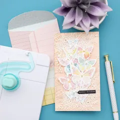 Slimline-Karte mit Schmetterlingsdesign und rosa Umschlag, Punch Board und Stift auf blauem Hintergrund
