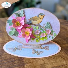 Sepiafarbene quadratische Karte mit Spatz und rosa-braunen Blüten im Oval-Rahmen, Spruch „Live simply, bloom wildly“.