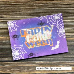 Violett-orange Shaker-Karte „Happy Halloween" mit Spinnen, Fledermaus und beweglichem Konfetti-Fenster.