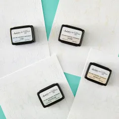 Die vier Mini-Stempelkissen dekorativ auf geprägtem Papier arrangiert.
