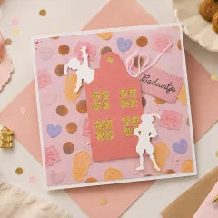 Quadratische Karte „Cadeautje" mit gestanztem Giebelhaus mit goldglitzernden Fenstern und weißen Piet-Silhouetten.
