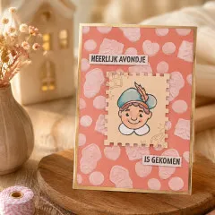 Karte „Heerlijk avondje is gekomen" mit geprägtem Süßigkeiten-Hintergrund und gestempeltem Piet-Gesicht im Briefmarken-Rahmen.