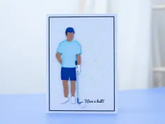 Karte mit männlicher Stanzfigur im hellblauen Golf-Outfit und Have-a-ball-Schriftzug