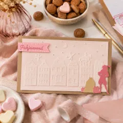 Karte „Pakjesavond" mit zartrosa geprägter Dächer- und Sinterklaas-Szene, rosa Banner und gestanzter Piet-Figur mit Geschenksack.