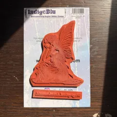 Ungemountetes Gummistempel-Set mit sitzender Fee und Textstempel auf Werbekarte.