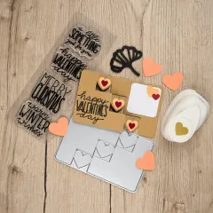 Gestaltete Valentinstagskarte mit Herz-Stanzungen neben Stempeln und Stanzschablone.
