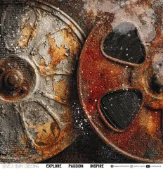 Nahaufnahme einer verrosteten, teils rot lackierten Filmspule