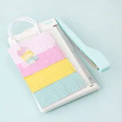 Mehrfarbig zugeschnittene Papierstücke in Rosa, Gelb und Türkis auf dem Mini Paper Cutter angeordnet