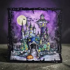 Bastelkarte mit farbig gestempeltem Spukschloss auf violettem Hintergrund, Mond, Fledermäuse, Zaun und dekorativer schwarzer Kartenrahmen
