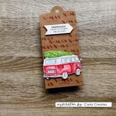 Kraftpapier-Tag mit rotem Bus samt Tannenbaum auf dem Dach und X-Mas Hintergrundstempel