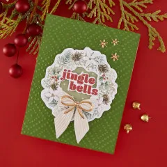 Selbstgemachte Weihnachtskarte mit Sleigh Bells Ring Ephemera Kranz und Schleife auf grünem Hintergrund