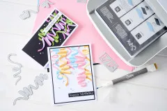 Übersicht aus Stanzformen, Karten und Zubehör neben der Sizzix Stanzmaschine