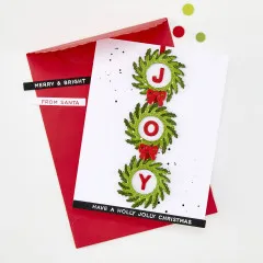 Weihnachtskarte mit drei grünen Kränzen, die die Buchstaben J, O und Y umrahmen, auf rotem Umschlag mit Grußtext 'Have a holly jolly Christmas'.