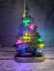 Bemaltes Beispiel der Woodology Christmas Tree Figur in Grün mit goldenem Stern und roten Schleifen.